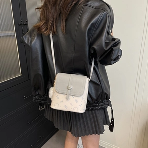 Mini flap crossbody bag with heart buckle and cat print shown on model's side profile