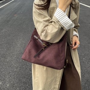 Grand sac cabas en daim bordeaux avec lanières en cuir porté par un mannequin
