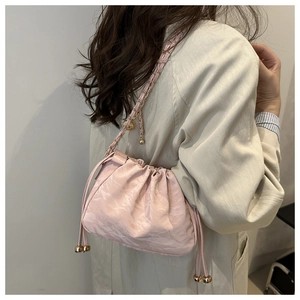 Détail du sac nuage plissé rose avec texture métallique, cordon et bandoulière dorée