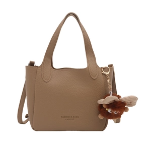 Retro khaki pebbled leather bucket bag with top handles and plush monster charm