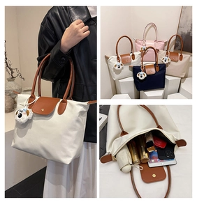 Détail du cabas en nylon avec anses en cuir et capacité pour les essentiels quotidiens