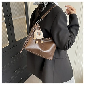 Sac demi-lune vintage marron avec breloque peluche et détail foulard sur mannequin