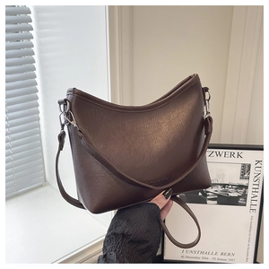 Détail du sac seau vintage en similicuir marron foncé avec finitions en métal argenté