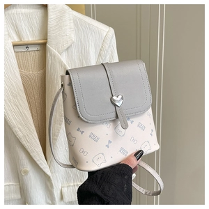 Detail of the cute cat print and heart-shaped metal lock on the mini PU leather bucket bag