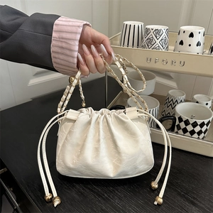 Sac seau à cordon chic en cuir marbré crème avec bandoulière chaîne dorée