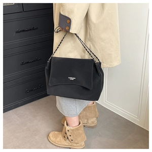 Détail d'un sac à bandoulière en similicuir noir plissé avec bandoulière chaîne