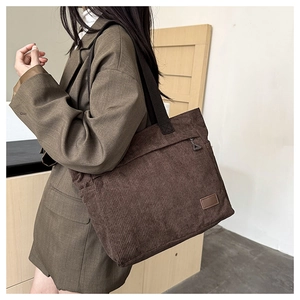 Detail of dark brown corduroy tote bag featuring thick texture and sturdy wide handles