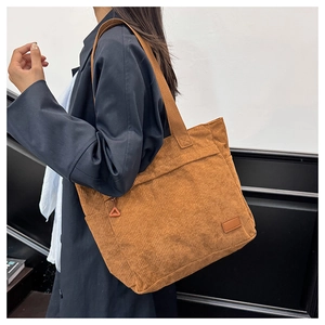 Detailed side view of brown corduroy tote bag showing its texture and large capacity