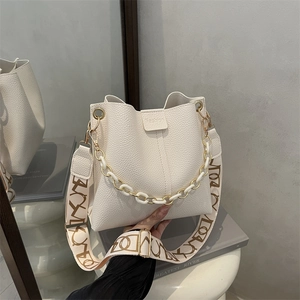 Cream white bucket bag with pebble leather texture and designer wide shoulder strap