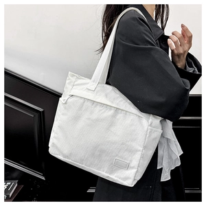 Close-up of white corduroy tote bag featuring striped texture and minimalist label patch