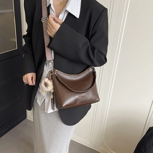 Sac seau rétro marron minimaliste avec bandoulière tissée et pendentif ours en peluche