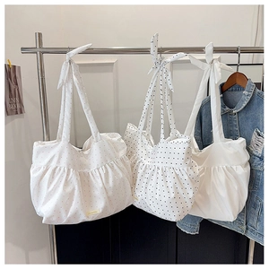 Three minimalist tote bags with tie-knot straps and elegant pleated details in various patterns