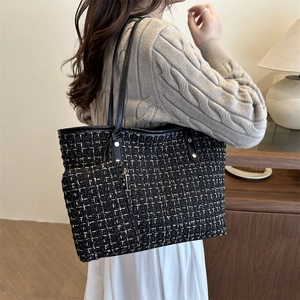 Classic black and gold tweed tote bag with matching pouch shown on a fashion model