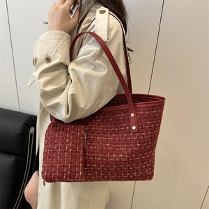 Red tweed tote bag with shoulder strap and matching mini pouch worn by a model