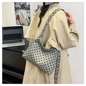 Detail of soft nylon tote bag with bold black polka dots on sage green fabric
