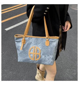 Detailed view of the large capacity grey canvas and brown leather stitching tote bag