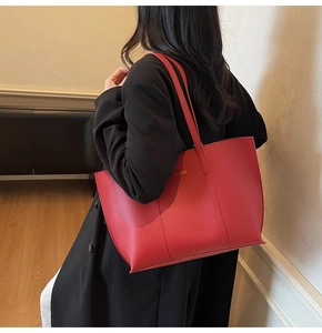 Dettaglio della borsa tote in pelle PU rossa opaca con scritte oro e manici lunghi