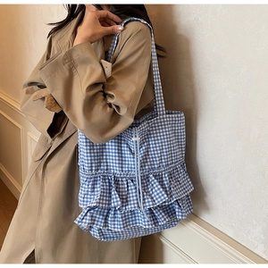 Close-up of blue and white checkered canvas tote bag with ruffle details and drawstring
