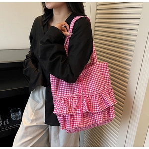 Detail view of pink gingham tote bag featuring layered ruffles and drawstring closure