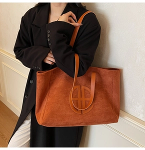Detail of vintage large-capacity tote bag in brown suede with circular leather patchwork