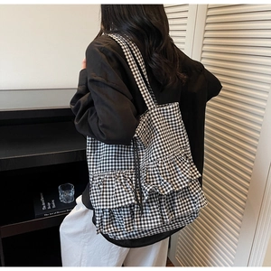 Detail of gingham tote bag featuring triple-layered ruffles and stylish check pattern