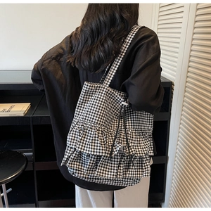 Detail view of the black and white gingham tote bag with double-layer ruffle accents
