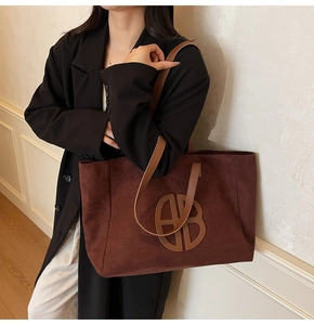 Macro detail of high-quality suede tote bag with circular logo and leather strap