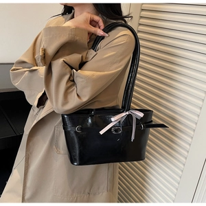 Détail du sac cabas noir brillant avec boucle en métal et ruban à carreaux chic