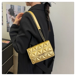 Detailed close-up of golden quilted chain bag with elegant metallic finish and stitching