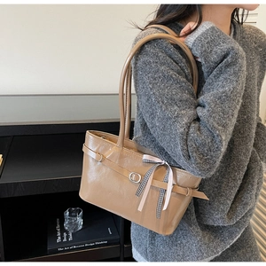 Dettaglio della borsa tote in ecopelle marrone chiaro con foulard di seta e fibbia a cintura