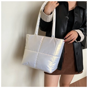 Detail showing the large quilted stitching and pearl finish texture of the tote bag