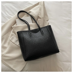 Détail de la texture tissée noire du grand sac cabas avec de longues bandoulières fines
