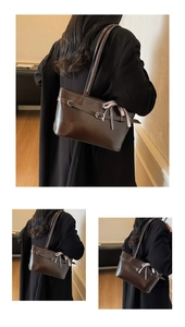 Détail d'un sac cabas en cuir brillant marron foncé avec boucle argentée et ruban à carreaux