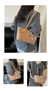 Détails du sac cabas en cuir caramel avec boucle argentée et ruban à carreaux noirs