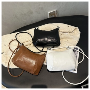 Chic baguette bags in black, brown, and white faux leather on soft knit fabric