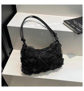 Détail de la texture de rose 3D sur sac à bandoulière en résille noire avec zip