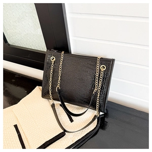 Détail du sac cabas noir à motif crocodile avec bandoulière en chaîne dorée