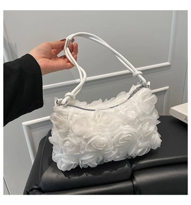 Détail de roses 3D en résille blanche sur un sac à main de soirée chic minimaliste