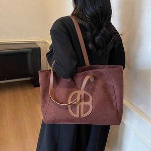 Retro large capacity tote bag in brown suede leather shown from a stylish side view angle