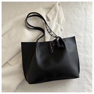Detailed top view of large black matte leather tote bag with a decorative silk scarf