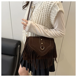 Détail du sac besace en daim marron avec longues franges et finitions métalliques dorées