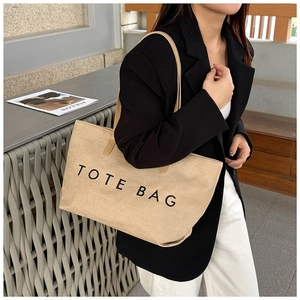 Detail einer großen beigen Canvas-Einkaufstasche mit schwarzem Tote Bag Aufdruck