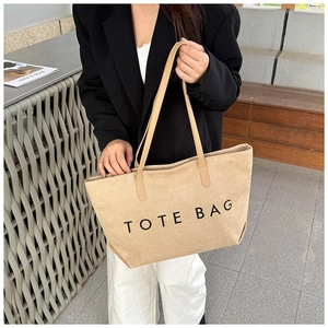 Minimalistische beige Tragetasche mit schwarzem Aufdruck in einer stilvollen Szene