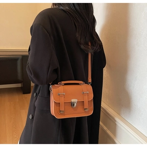 Detailansicht einer karamell-orangen Vintage-Umhängetasche mit Klappe und Schnallen