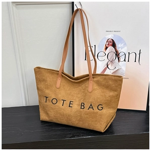 Detail der braunen Wildledertasche mit schwarzem TOTE BAG Aufdruck und Lederriemen