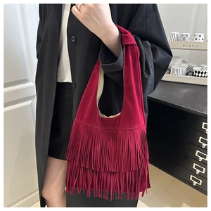 Dettaglio borsa a spalla in camoscio rosso con tre strati di lunghe nappe bohémien