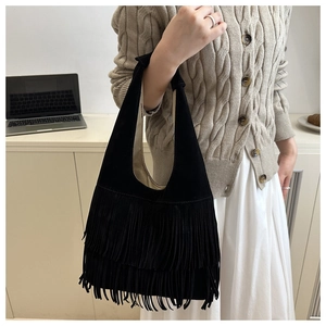 Detail of black vintage tassel tote bag in soft suede finish with large capacity design