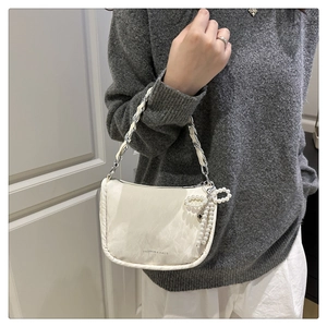Sac demi-lune blanc avec texture nuage douce et détail élégant de nœud en perles
