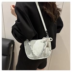 Détail du sac bandoulière vert menthe avec chaîne argentée et breloque nœud perlé