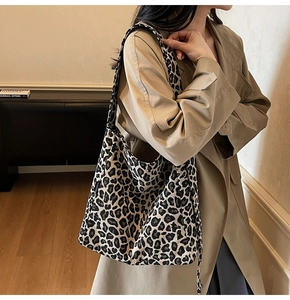 Detail of high-capacity leopard print canvas crossbody bag with wide shoulder strap